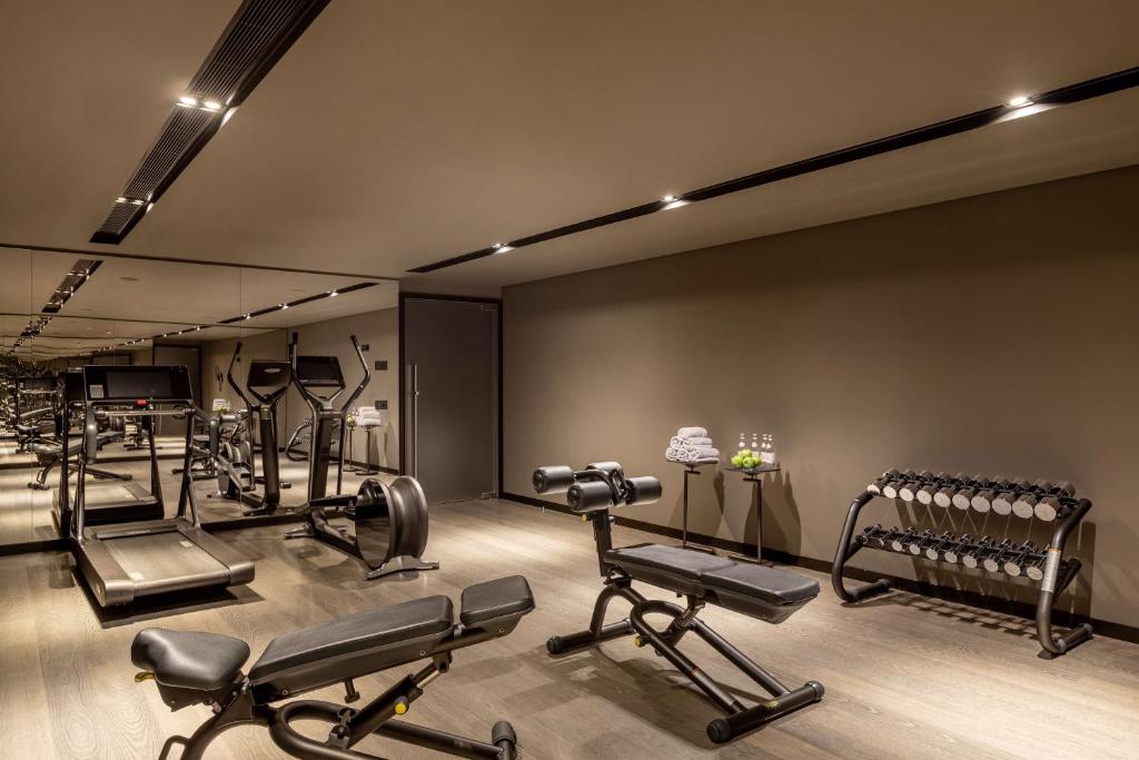 a gym with a row of exercise equipment in a room at Tivoli Portopiccolo Sistiana Wellness Resort & Spa in Sistiana