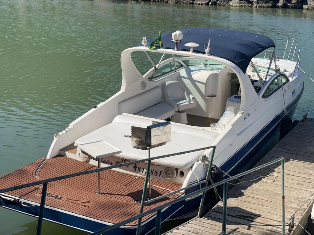 a white boat parked at a dock in the water at Embarcação Arlequina in Rio de Janeiro