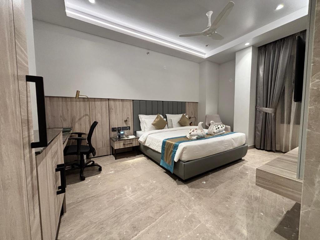 ein Hotelzimmer mit einem Bett und einem Schreibtisch in der Unterkunft The Eastern Grace Hotel in Buxar