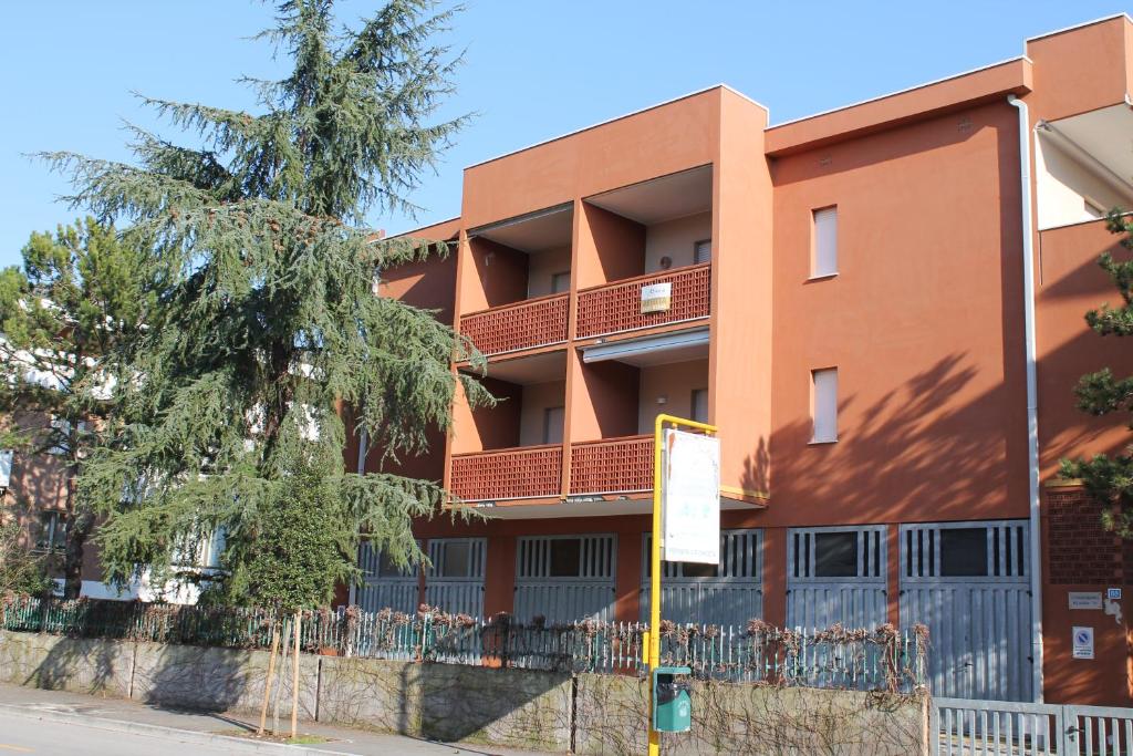 un edificio arancione con un albero di fronte di Appartamento Renata a Grado