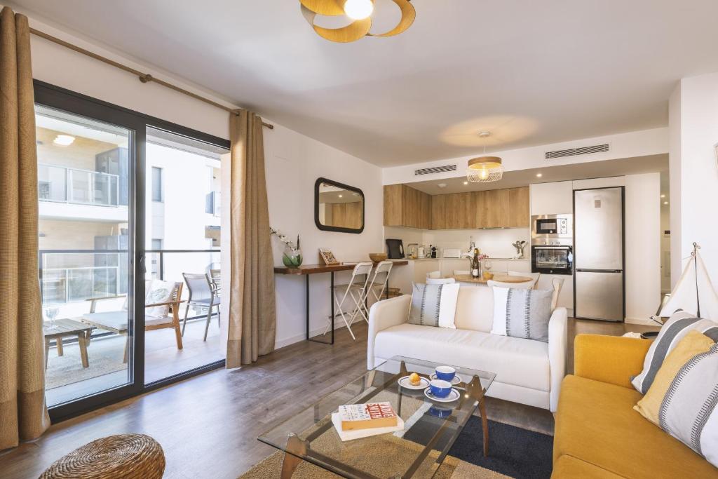 a living room with a couch and a kitchen at Nova Essential in Jávea