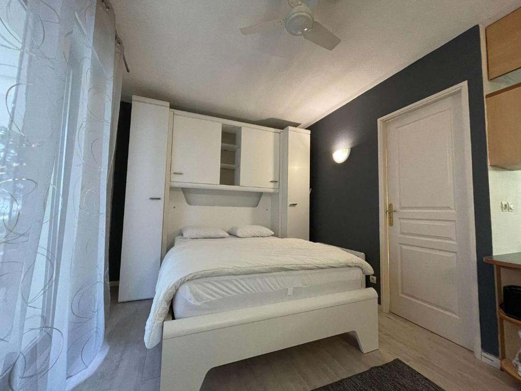 une petite chambre avec un lit blanc et un placard blanc dans l'établissement Appt Studio LA ROCHELLE - LR010-041, à La Rochelle