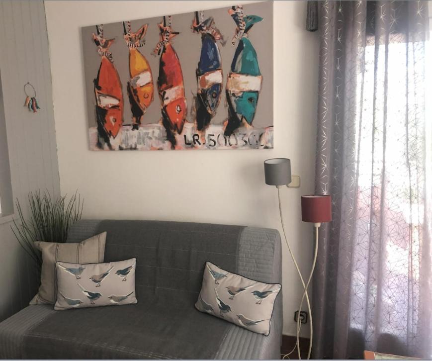 a living room with a couch and a picture of surfboards at For Sea Lovers in Cubelles