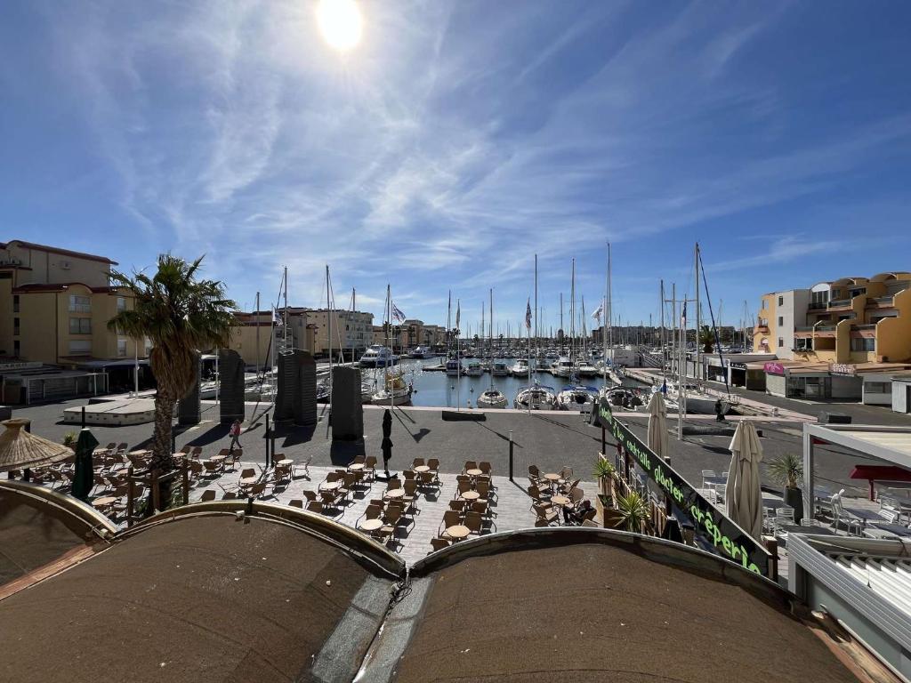 une marina avec un groupe de personnes assises sur une terrasse dans l'établissement Appartement 2 pièces cabine - Gruissan GN130-820, à Gruissan