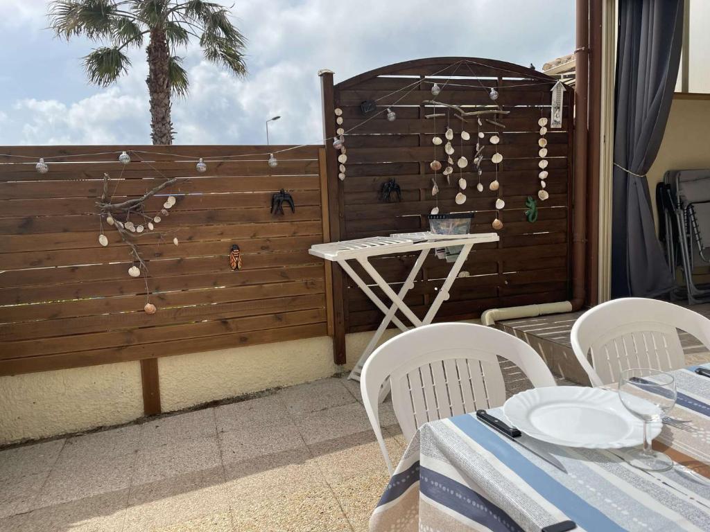un patio avec une table et des chaises et une clôture dans l'établissement SP570-70L Mais 2 pièces mezzanine SAINT PIERRE LA MER, à Saint Pierre La Mer