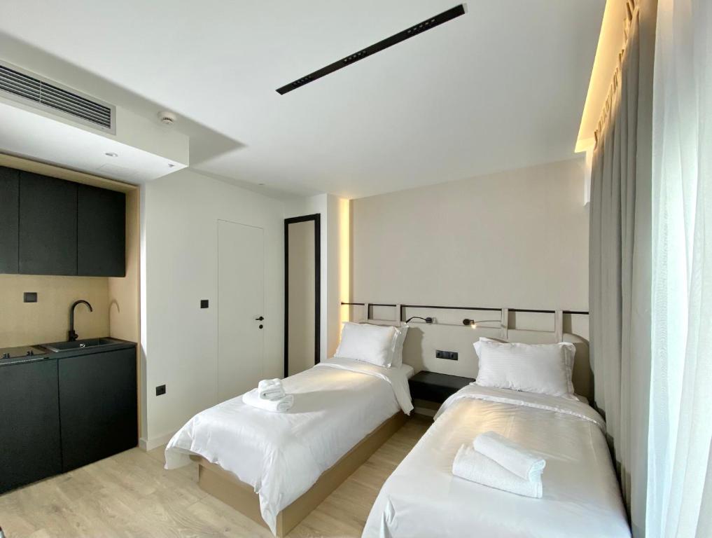 a bedroom with two beds and a sink at ICON Urban Living in Thessaloniki
