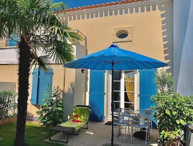 a blue umbrella sitting next to a table and chairs at Mais 2 pièces mezza CHATELAILLON PLAGE - CL080-022 in Châtelaillon-Plage