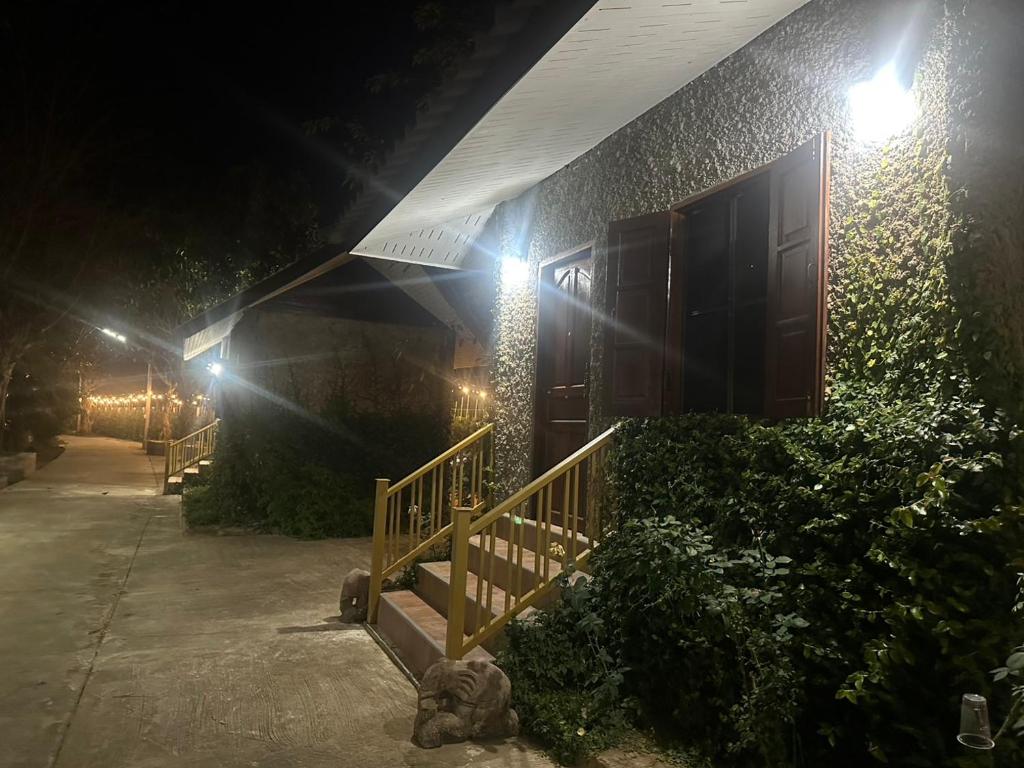 a building with lights on the side of it at night at Rublom Resort Mae Taeng in Ban Pak Thang