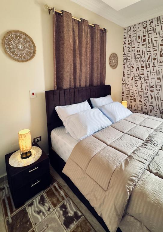a bedroom with a bed and a lamp on a night stand at Horus pyramids view in Cairo
