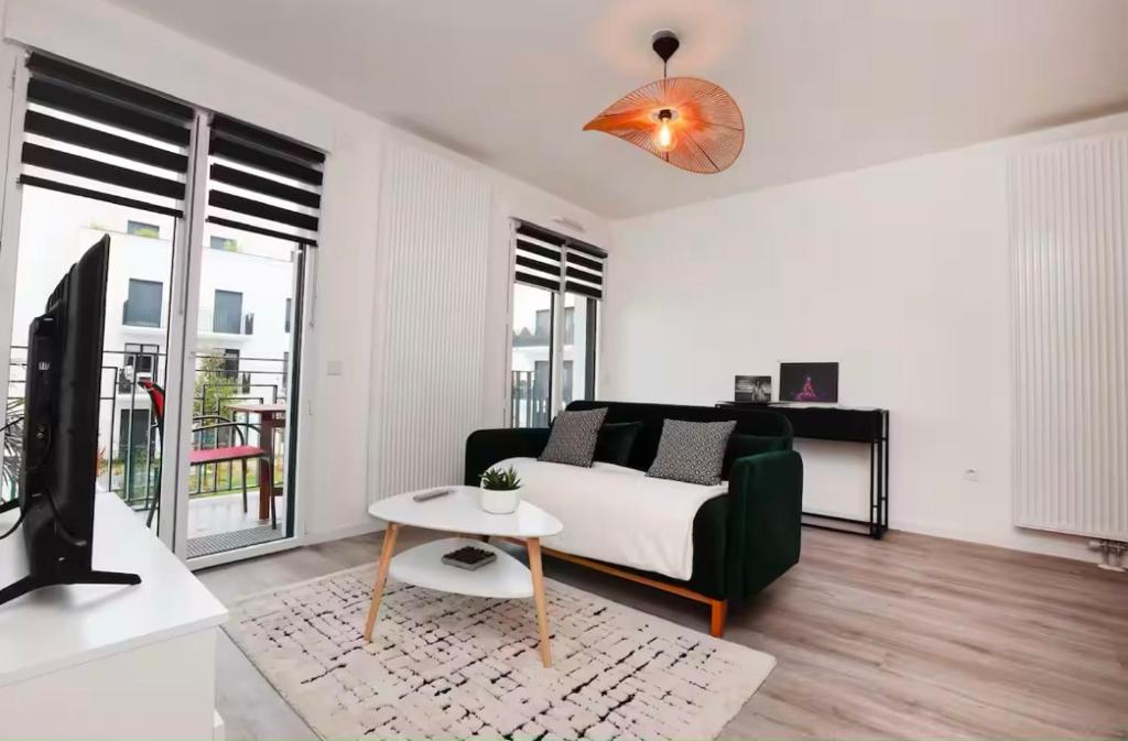 un salon avec un canapé et une télévision dans l'établissement Appartement 10 minutes Disneyland - parking gratuit, à Chessy
