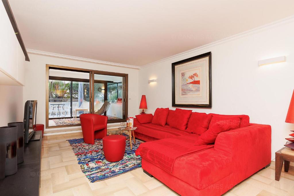 un salon avec un canapé rouge et une télévision dans l'établissement Gray 2A2, à Cannes