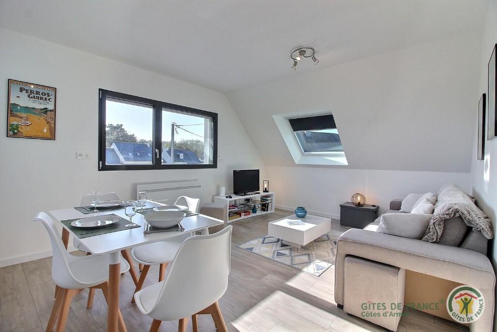 ein Wohnzimmer mit einem Tisch und einem Sofa in der Unterkunft Les agapanthes in Perros-Guirec