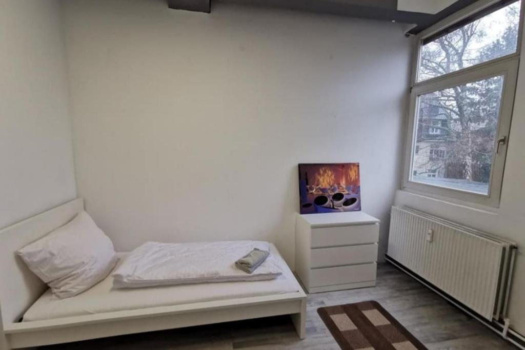 a white room with a bed and a window at 3 Zimmer Wohnung in Itzehoe in Itzehoe