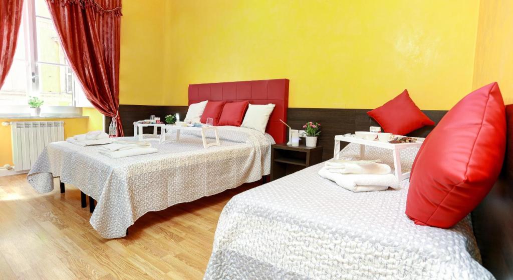 1 Schlafzimmer mit 2 Betten und roten Kissen in der Unterkunft Termini Suites in Rom