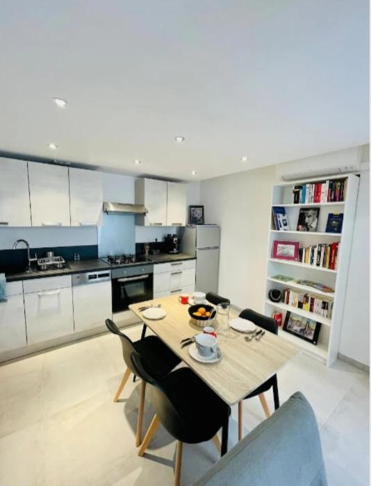 une cuisine avec une table et des chaises dans une pièce dans l'établissement Cœur de Sète Le Patio 1, à Sète