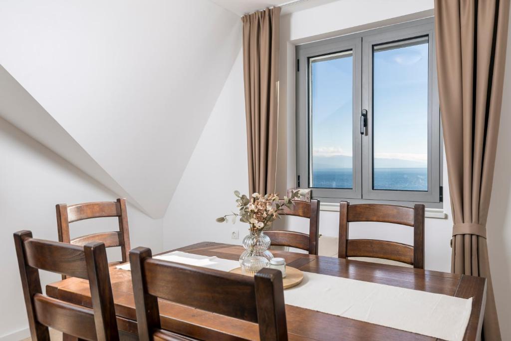 una sala da pranzo con tavolo, sedie e una finestra di Esperia a Opatija