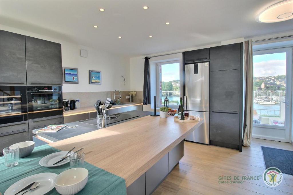 une grande cuisine avec un grand comptoir en bois dans l'établissement La maison du pont, à Trédarzec