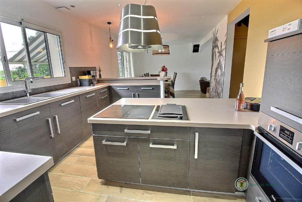 a large kitchen with a sink and a stove at Ty antely in Trédarzec