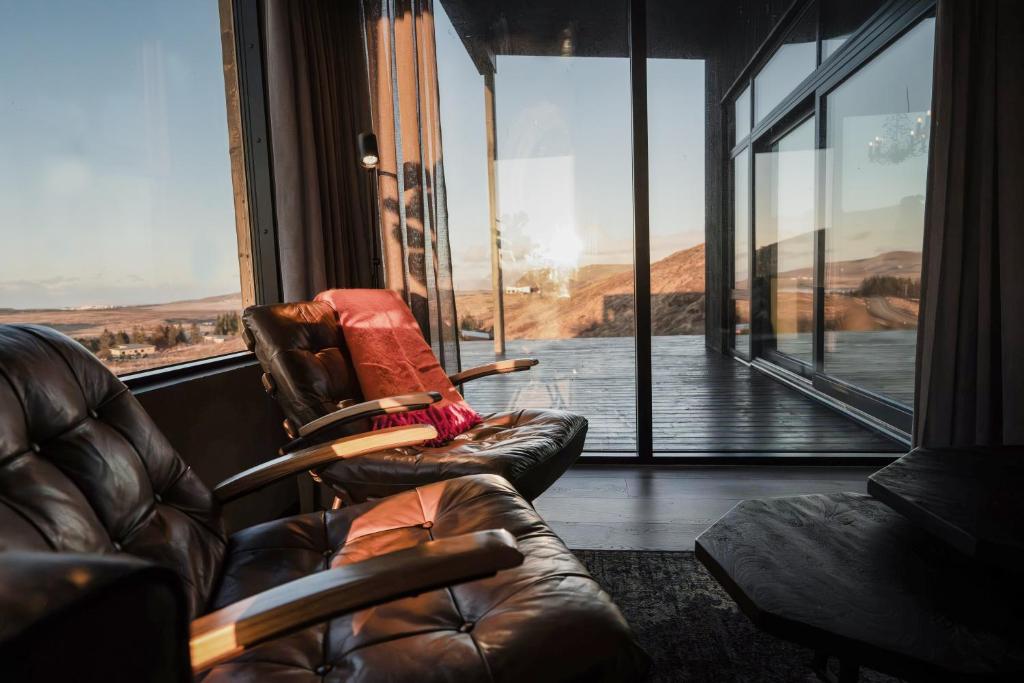 two leather chairs in a room with a large window at Black Diamond Villa in Mosfellsbær