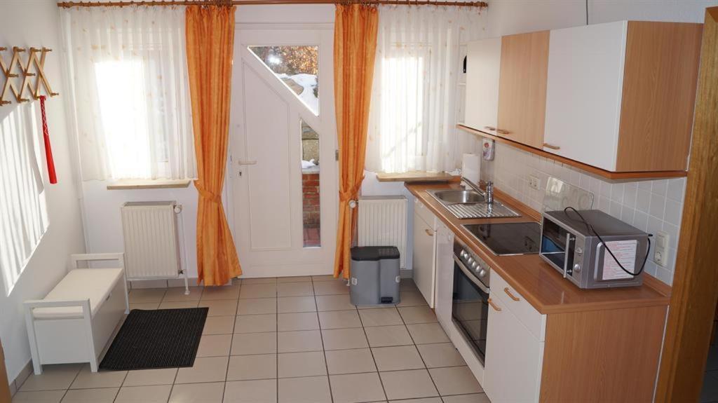 a kitchen with a sink and a microwave at Ferienwohnung Schlichting in Travemünde