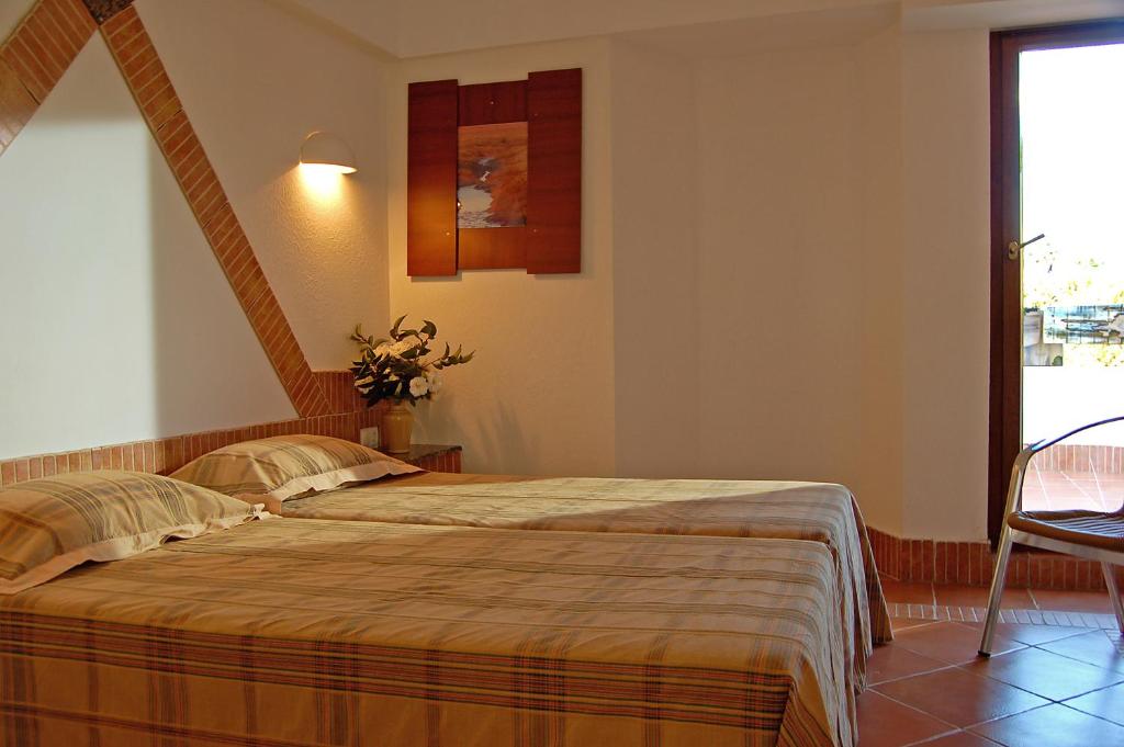 a bedroom with a large bed and a window at Pedras D'el Rei in Tavira