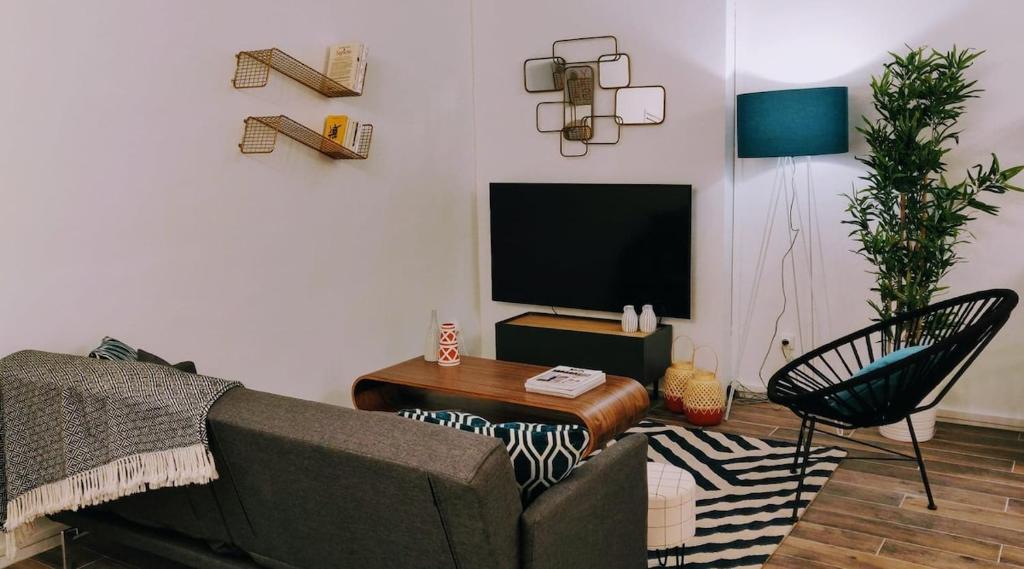 un salon avec un canapé et une télévision dans l'établissement Grand Apt 4 Chambres - Terrasse - Moderne - Centre d'Evry, Évry-Courcouronnes