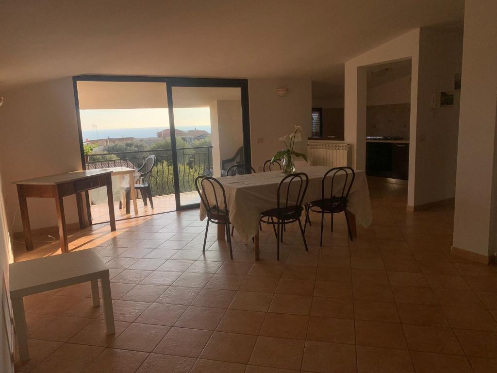 a dining room with a table and chairs and a balcony at Casa vacanze Apollonia in Marina di Camerota