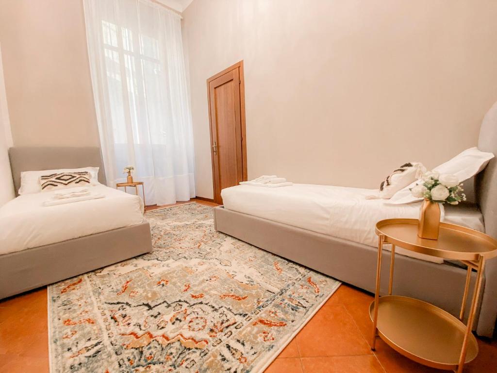 Un dormitorio con dos camas y una mesa. en Ponte Pietra Lovely Home in Verona, en Verona