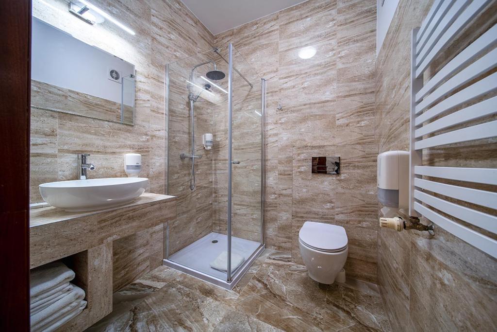 Modern bathroom with glass shower, marble tiles, and sleek fixtures.