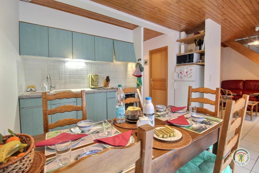 a kitchen and dining room with a table and chairs at La horen in Plérin
