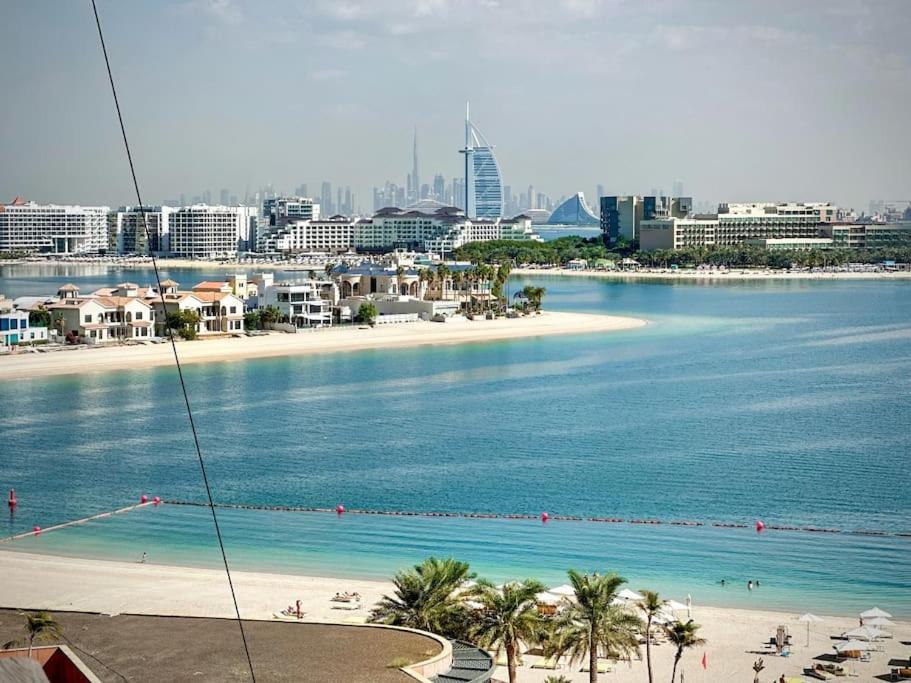 a view of a beach with palm trees and buildings at Fantastic flat in TiaraResidence in Dubai