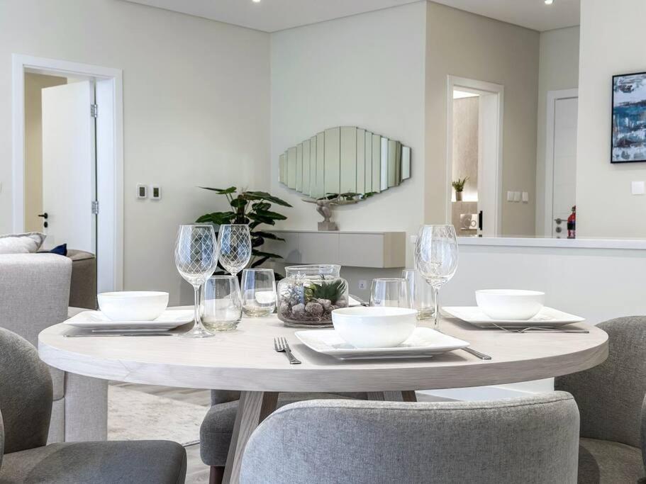 a white dining room table with glasses and chairs at Fantastic flat in TiaraResidence in Dubai