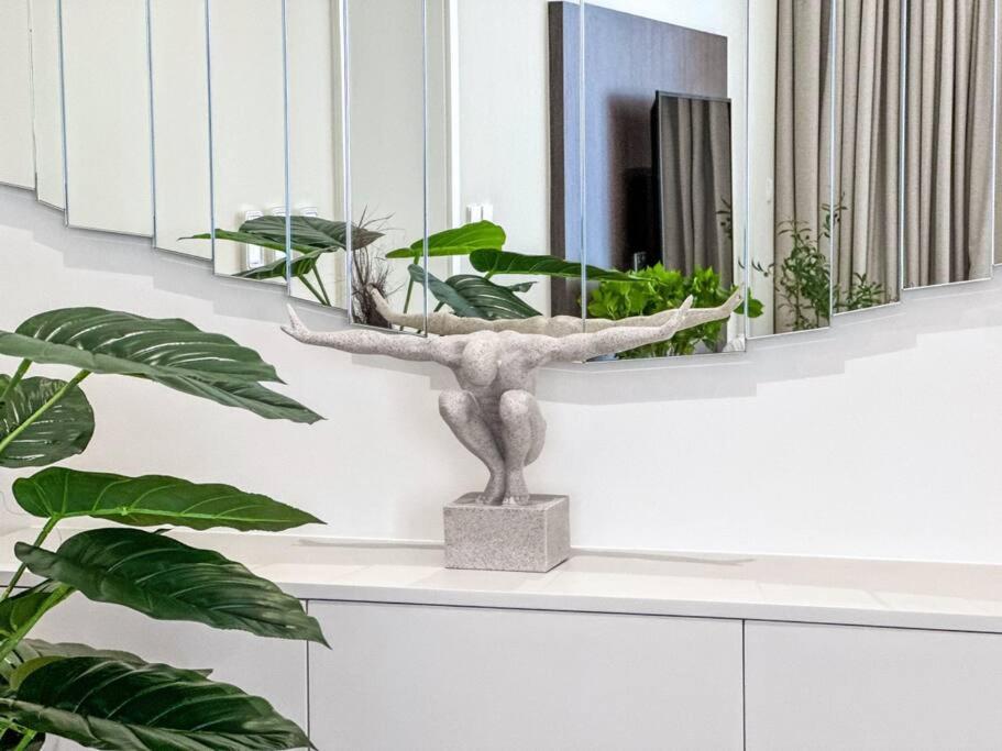 a plant sitting on a counter next to a mirror at Fantastic flat in TiaraResidence in Dubai
