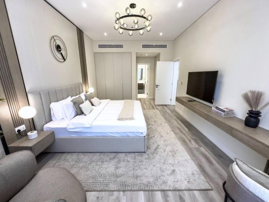 a bedroom with a large bed and a tv at Fantastic flat in TiaraResidence in Dubai
