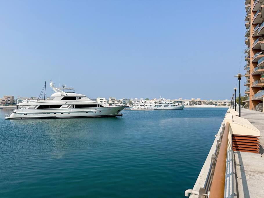 a boat is docked in the water next to a dock at Fantastic flat in TiaraResidence in Dubai