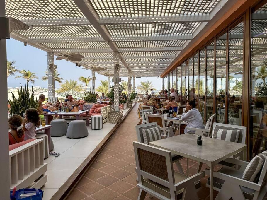 a restaurant with people sitting at tables on a patio at Fantastic flat in TiaraResidence in Dubai