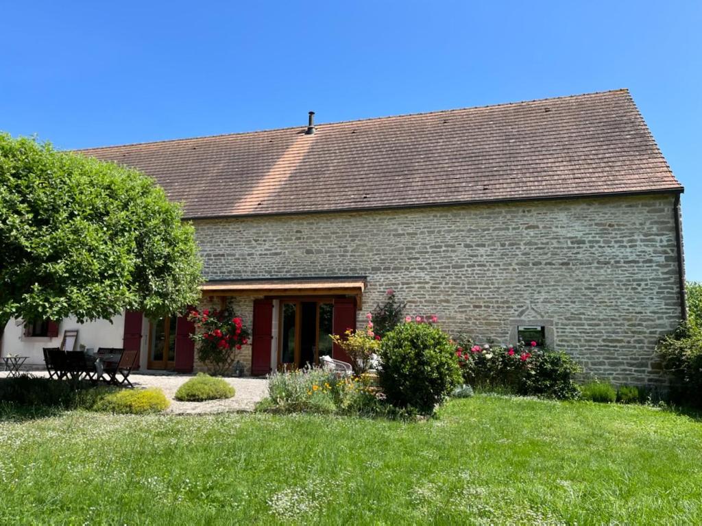 a brick house with a yard with grass and flowers at Les Prés d'Allerey in Allerey-sur-Saone