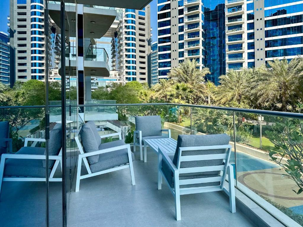 a balcony with chairs and a table and a view of a city at Renovated Marina view apartment in Oceana in Dubai