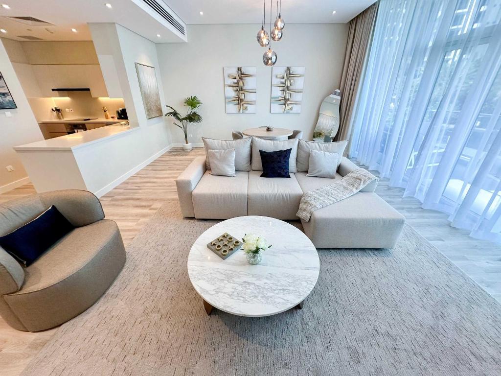 a living room with two couches and a table at Renovated Marina view apartment in Oceana in Dubai