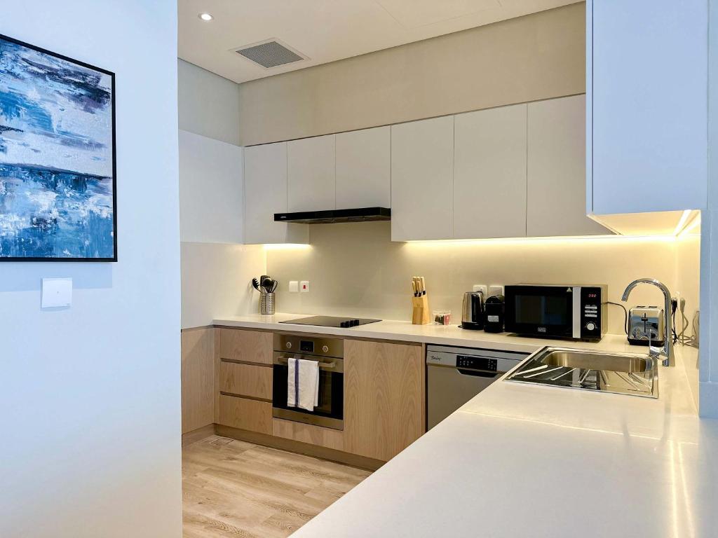 a kitchen with white cabinets and a sink at Renovated Marina view apartment in Oceana in Dubai