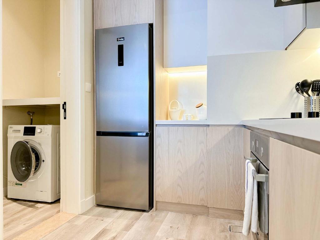 a kitchen with a refrigerator and a washing machine at Renovated Marina view apartment in Oceana in Dubai