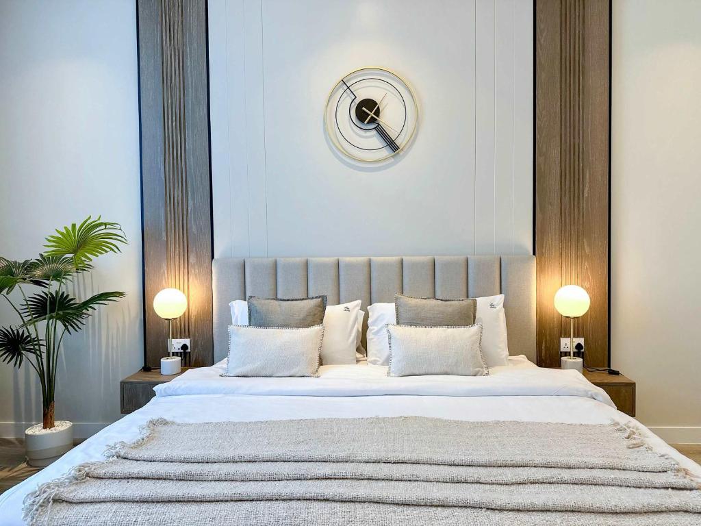 a bedroom with a large white bed with two lamps at Renovated Marina view apartment in Oceana in Dubai