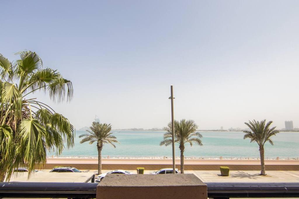 - une vue sur une plage avec des palmiers et des voitures dans l'établissement Relaxing 1 bedroom apartment at 5 Star Resort, à Dubaï