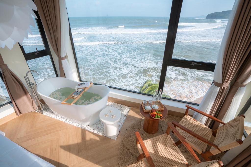 a bath tub in a room with a view of the ocean at Sunsea House-Đá Đĩa Phú Yên in Tuy An
