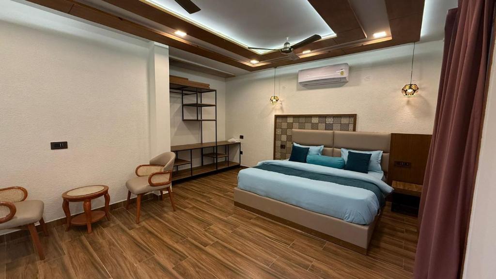 a bedroom with a bed and a table and chairs at Yes Hotel By The Ganges in Rishīkesh