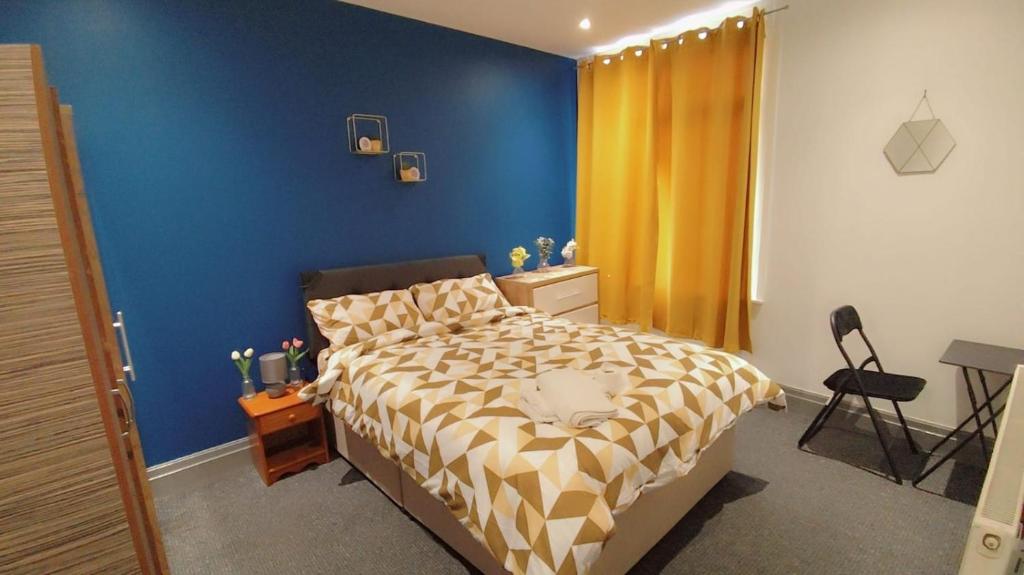 une chambre avec un lit avec un mur bleu dans l'établissement Double-Bedroom in the Heart of Eccles Manchester Perfect for Short Stays BH2, à Manchester
