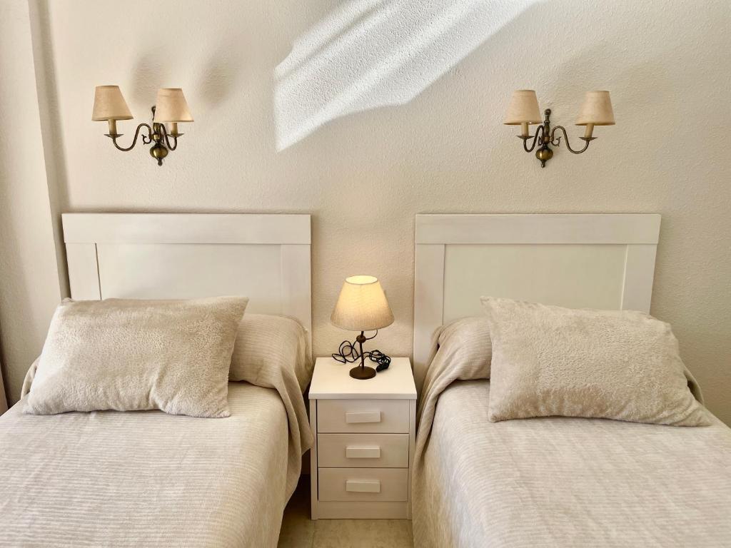 dwa łóżka siedzące obok siebie w sypialni w obiekcie Relax y Confort, Apartamento Reformado con Piscina w mieście Benidorm