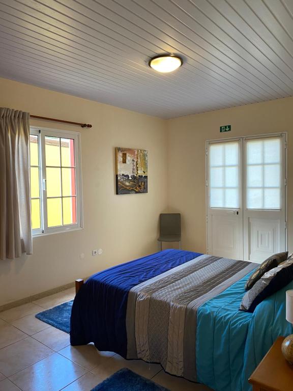 - une chambre avec un lit, 2 fenêtres et un plafond dans l'établissement caminho da praia da maiata, à Porto da Cruz