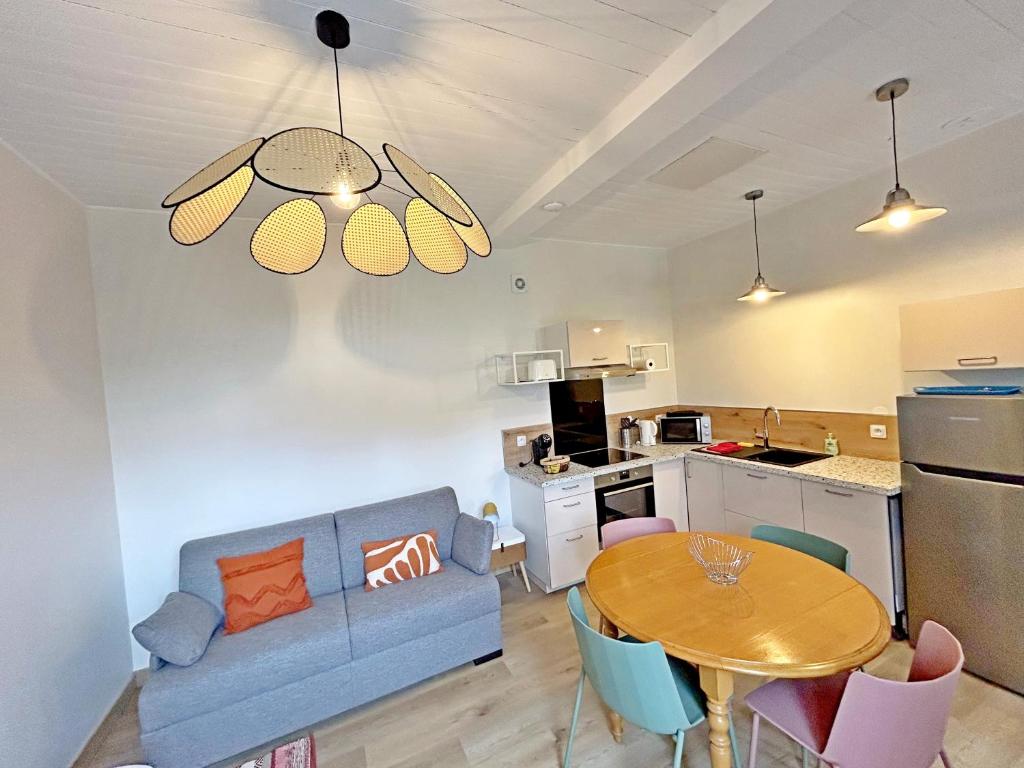 un salon avec un canapé bleu et une table dans l'établissement Gite Grand Chantilly -Maison 2CHB-2SDB 6p & Studio 2p, à Châteauroux