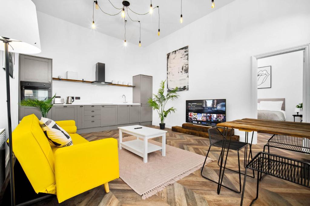 a living room with a yellow couch and a table at Stylish 2 Bedroom Apartment - Free WiFi - Netflix - Wolverhampton Centre - 2TO in Wolverhampton